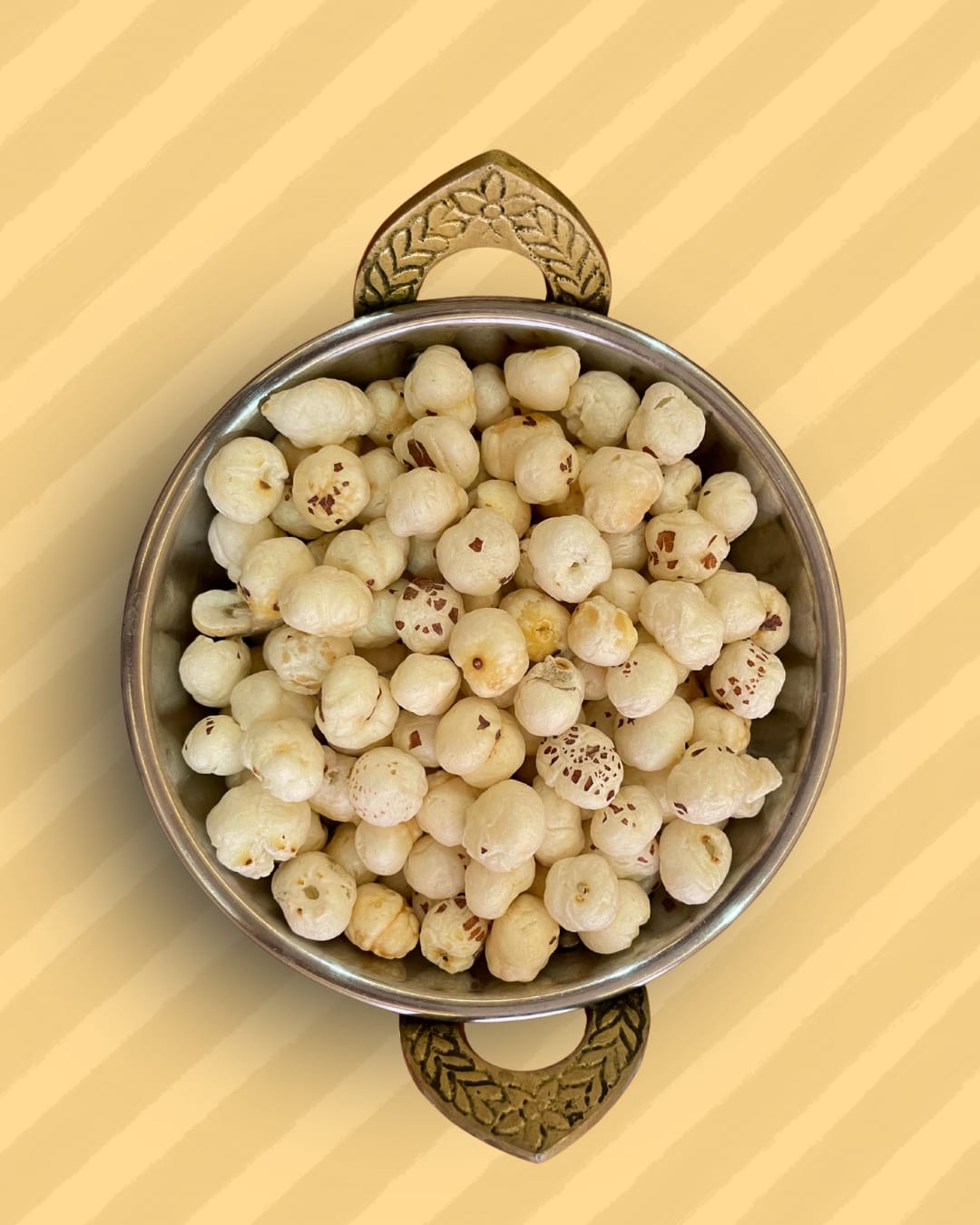 A pan holding 4 Suta Phool Makhana to show the size and texture of the fox nuts for customer reference